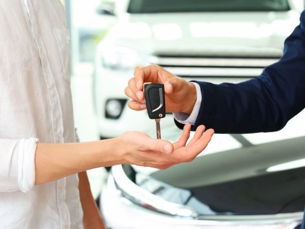 Professional car rental agent handing vehicle keys to customer for camping 4x4 hire Kenya safari adventure