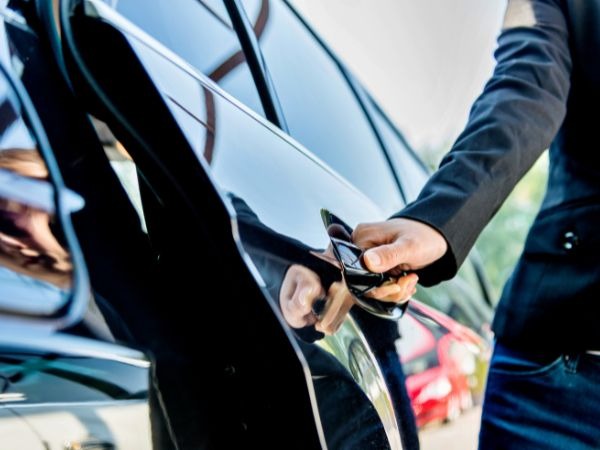 Premium car hire Kenya - business traveler accessing luxury rental vehicle with smart key